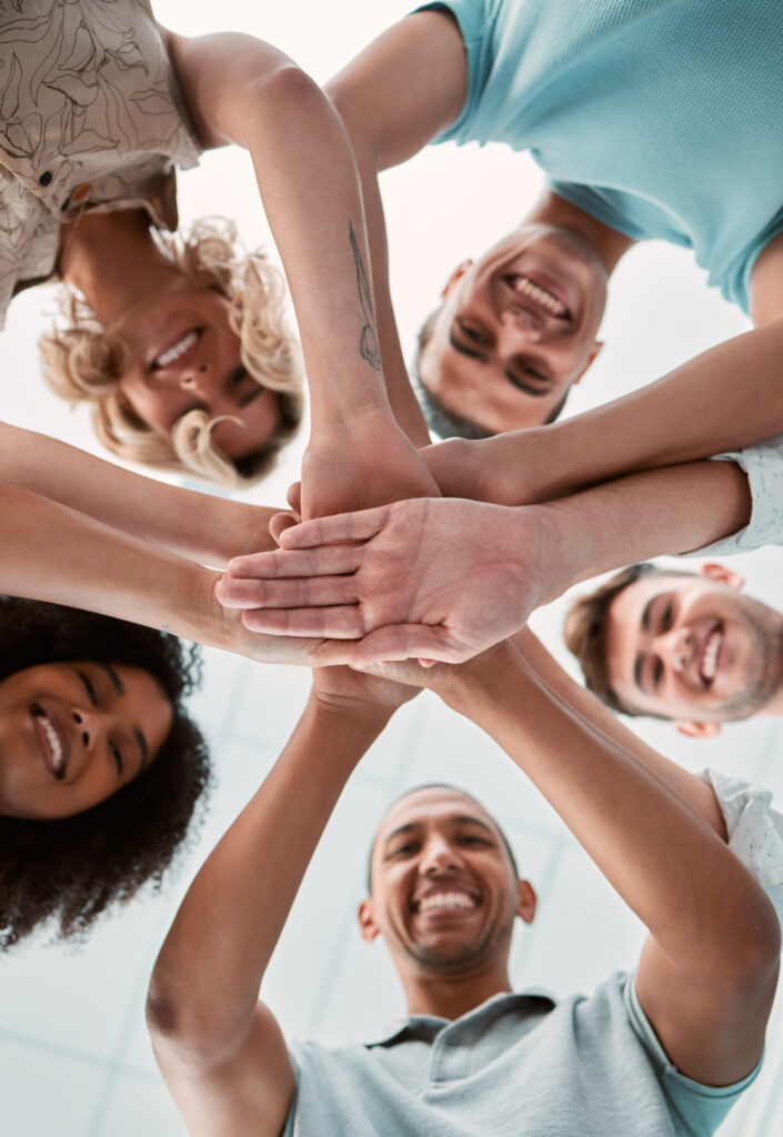 Hands together, support and teamwork people for business collaboration, team building and work motivation. Happy group of people stacked sign for mission, community trust and diversity success below